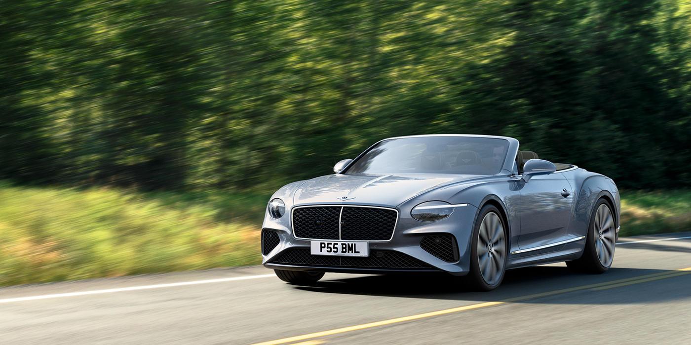 Bentley Jakarta New Bentley Continental GTC convertible front view in Silverlake paint with 22 inch ten spoke wheels, driving dynamically on a country road